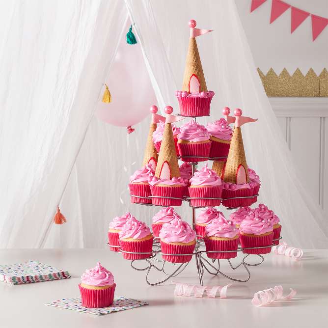 Make cupcakes from white cake mix, frost with Funfetti pink frosting (we like using a star piping tip) and decorate with sugar crystals and Wilton White Pearl Sprinkles. Arrange on a cupcake stand, saving 6 to top with sugar cone turrets. To make turrets, cut pieces of Juicy Fruit bubble gum for the flag and door. Pipe pink frosting on the tip and base of each cone and press Juicy Fruit pieces to the cone. Let dry, top 6 cupcakes with the cone turrets and place on the stand.

Tip: Finishing touches: outline the turret doors with Wilton Sparkle Food Color and add pink Sixlets accents.