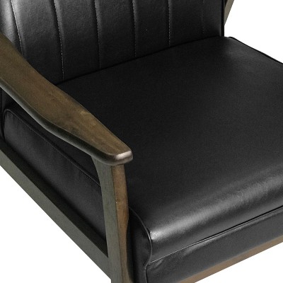 Close-up of black faux leather seat and wooden armrest on chair