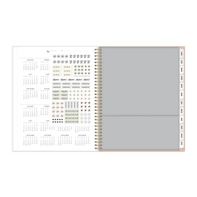 An open Everygirl Planner showing a calendar with planner stickers on one side and a blank page on the other side