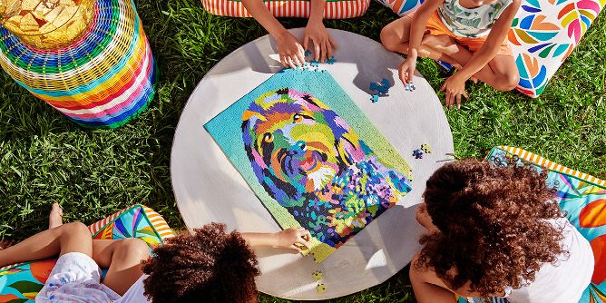 4 kids gathered around a table putting together the colorful Blacky artwork puzzle.