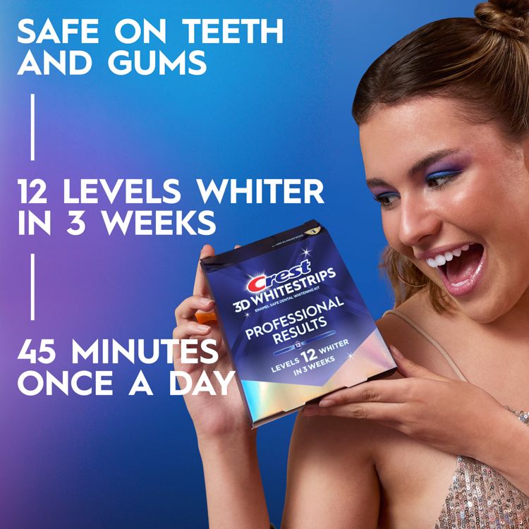 A person holding a box of Crest 3D Whitestrips Professional Results with text stating "Safe on teeth and gums," "12 levels whiter in 3 weeks," and "45 minutes once a day."