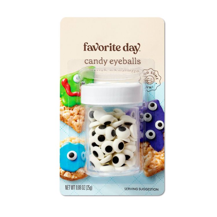 A small plastic jar filled with candy eyeballs, labeled "favorite day candy eyeballs," with a net weight of 0.88 oz (25g), displayed on a card featuring decorated treats.