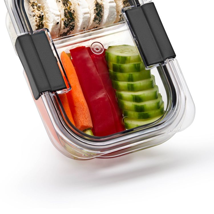 Clear plastic container with black clips, holding sliced cucumbers, red bell peppers, carrots, and seasoned chicken.