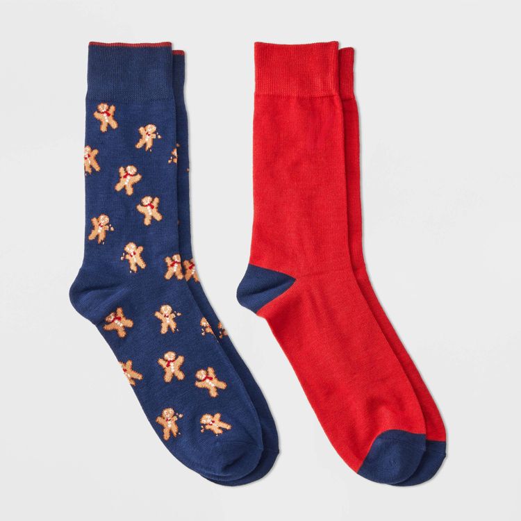 One blue colored sock with gingerbread man pattern and one solid red colored sock with blue accents.