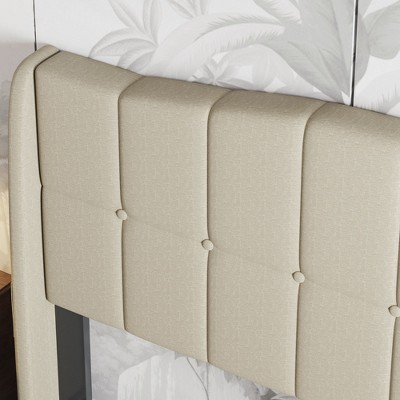 Close-up of beige tufted headboard with visible buttons