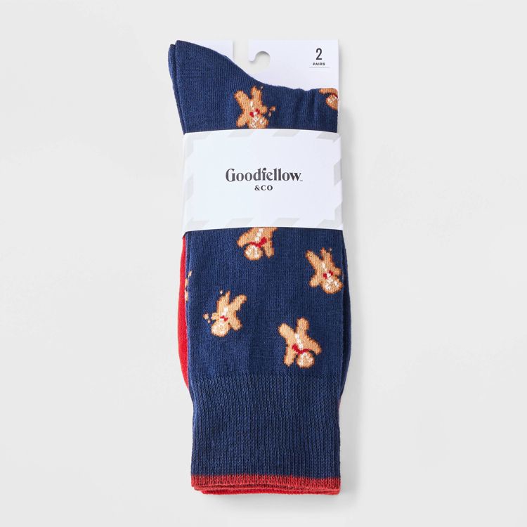 Two pairs of socks, one navy blue colored with gingerbread man patterns and the other red colored, packaged together with a label reading "Goodfellow & Co."