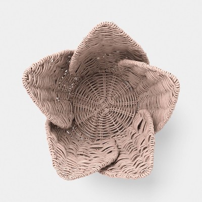 A pink colored woven basket with a flower-like shape viewed from above.
