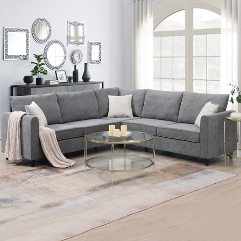 Beige 3 seater sectional couch with green and gray accent pillows