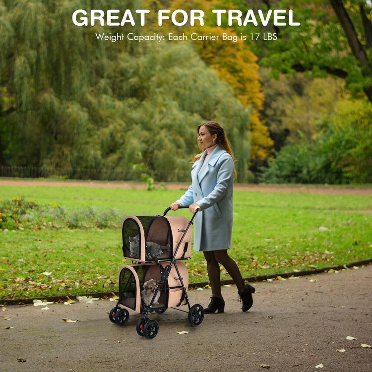 A woman pushes a double-decker pet stroller with mesh windows, containing a cat and a dog, in a park setting.