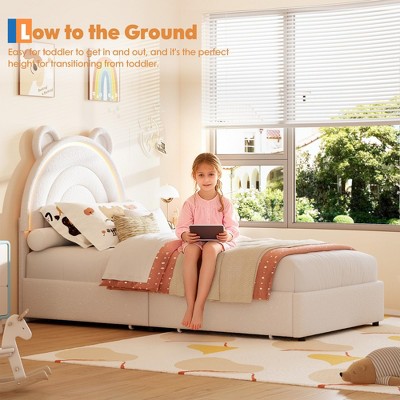Child sitting on bed with tablet in bright room