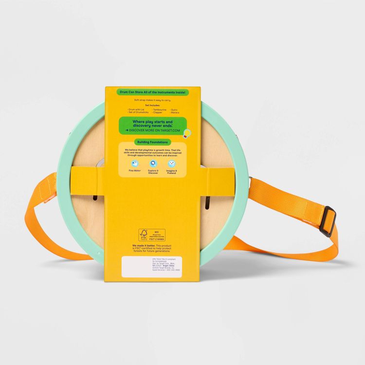 A round drum with a light blue colored rim and orange strap, featuring a yellow label with text about storing instruments and building foundations.