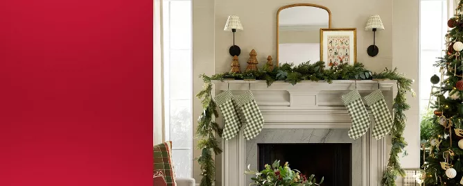 Mantel styled with plaid stockings, wicker decor trees and Christmas wall art