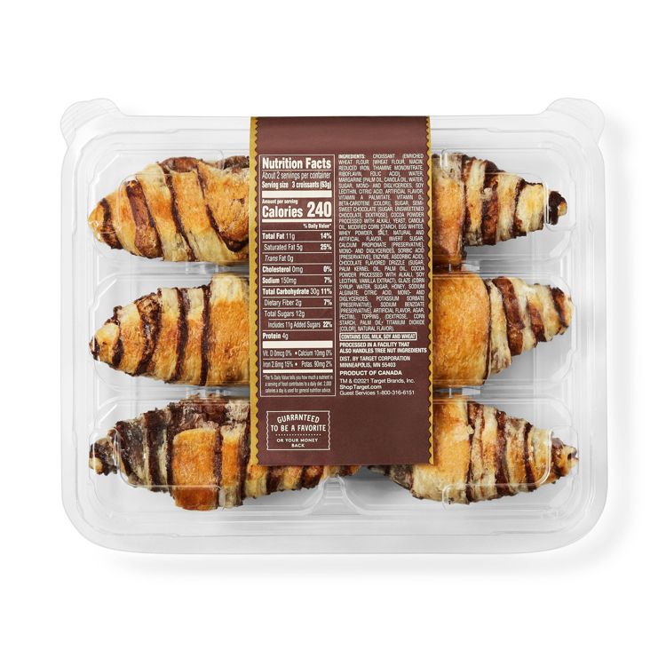 A clear plastic container holding six chocolate-striped croissants with a visible nutrition facts label showing 240 calories per serving.