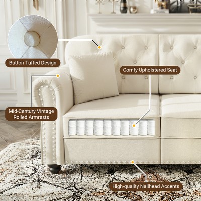 Close-up of tufted armrest and nailhead trim on cream sofa