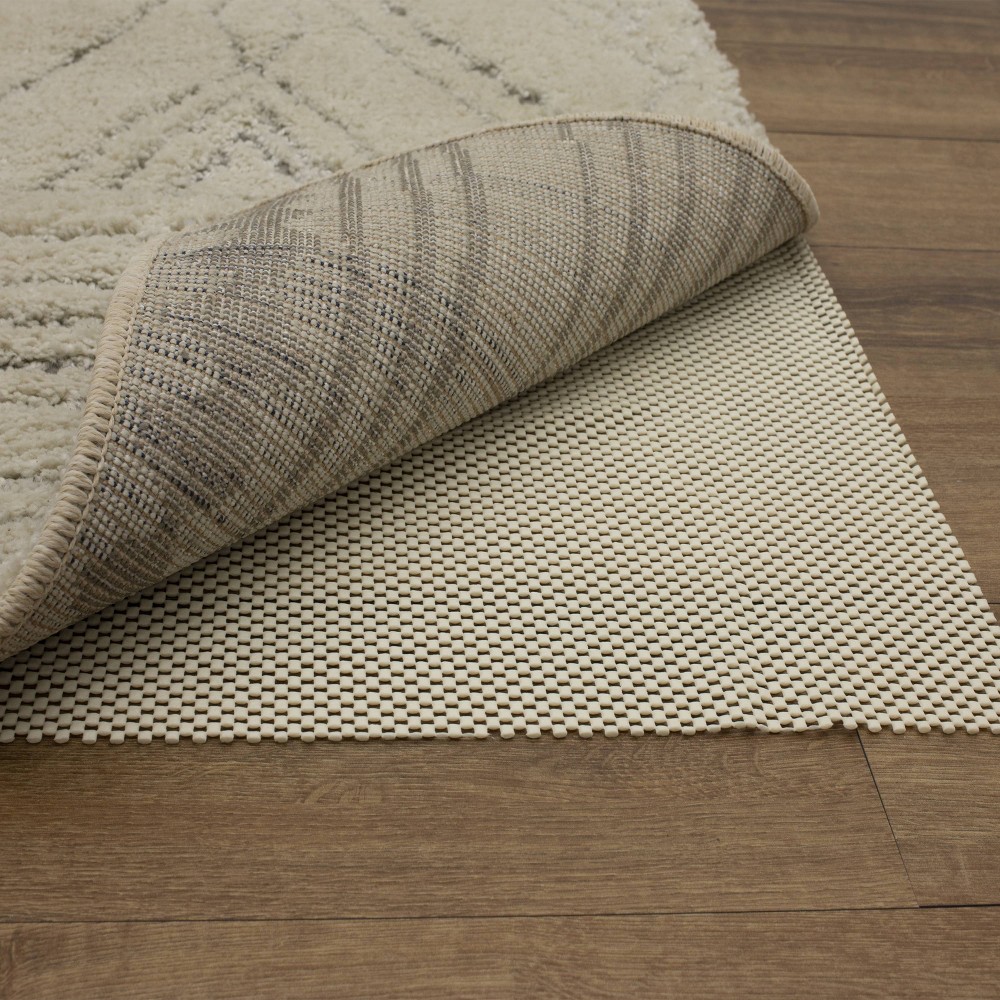 1'8 x2'6  Comfort Grip Rug Pad Ivory - Mohawk Home Keep the flooring in your home protected and add cushion underneath your favorite area rug with the Ivory Cushion Plus Non-Slip Rug Pad from Mohawk. Made for use on hard surface flooring, this polyester waffle rug pad can easily be trimmed down to size with household scissors, perfectly fitting any size rug in your home. Its sleek 1/16” thickness adds extra cushioning where you need it most, without being too bulky. Rug pads have many benefits, including keeping area and accent rugs in place, protecting against abrasion and wear on all flooring types, reducing pile crushing from furniture, and making vacuuming easier, too! Size: 1'8 x2'6 . Color: One Color.