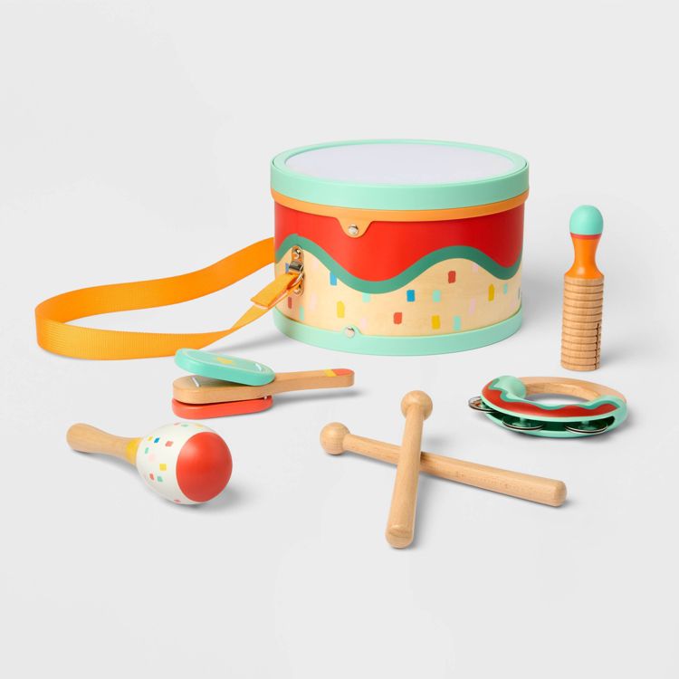 A colorful children's percussion instrument set including a drum with a strap, maracas, a tambourine, and wooden sticks.
