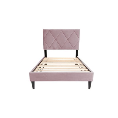 Single view of the pink upholstered bed corner showing headboard and legs