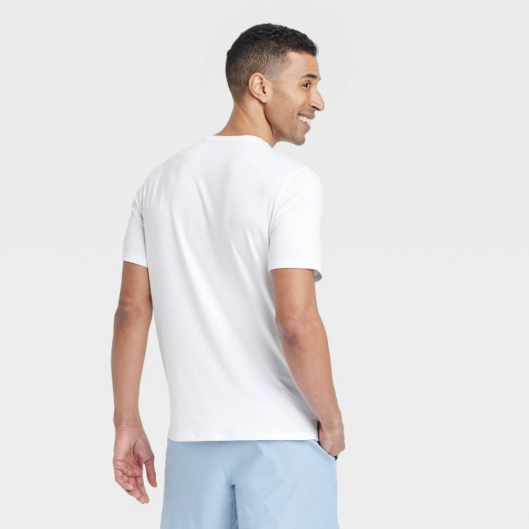 White colored short-sleeve t-shirt viewed from the back, worn by a person.