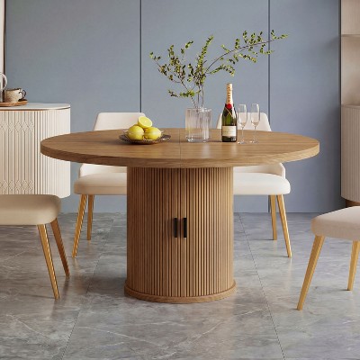 Round wood dining table with ribbed pedestal base in dining setup