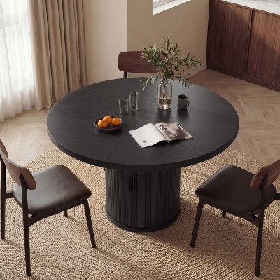 Round dark wood dining table with ribbed pedestal base viewed from above