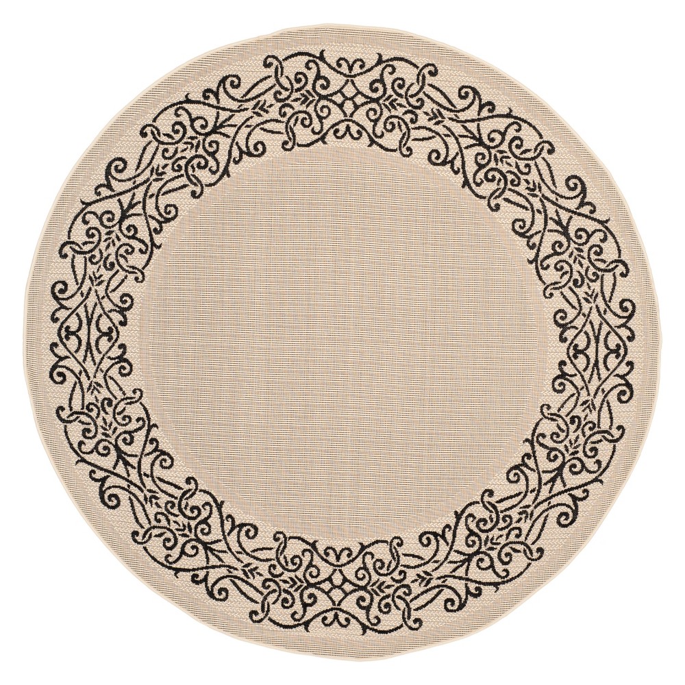 5'3  Round Bari Outdoor Rug Sand/Black - Safavieh Create an inviting space on your patio or deck with this classy Round Patio Rug. This woven area rug has a decorative, black filigree border on a neutral beige tone. The diameter is approximately 5'3 , making it a great size to highlight a cozy seating area. The durable outdoor rug resists stains, mildew and fading, so you can enjoy it for years to come. Styled with a metal café table and chairs, it makes a perfect spot to gather around. Size: 5'3  ROUND. Color: Sand/Black. Pattern: Geometric.