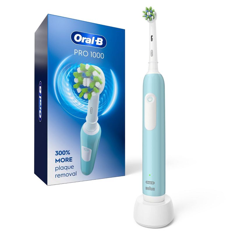 Oral-B Pro 1000 Green Electric Toothbrush package. Includes Toothbrush, Cross Action Replacement Brush Head, and charger. Features image of an oscillating toothbrush. Removes 300% more plaque along the gumline.