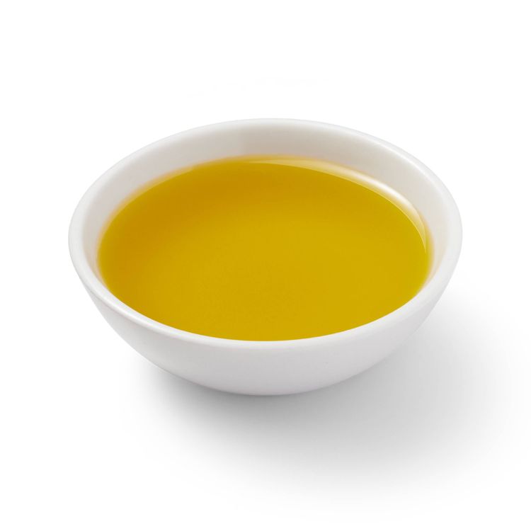 A white bowl filled with yellow colored oil.