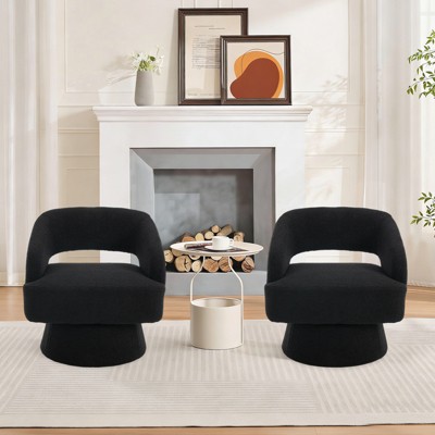 Two black swivel barrel chairs set in living room with small round table in front; fireplace in background