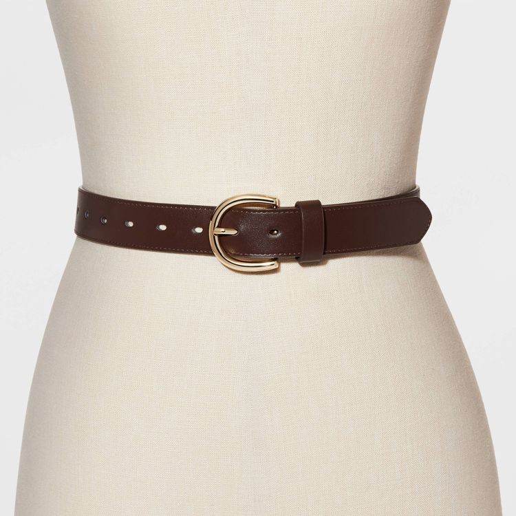 A brown colored belt with a gold colored buckle displayed on a mannequin.