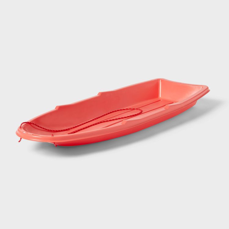 A red colored sled with a matching red rope handle on a white background.