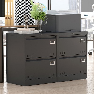 Four-drawer black metal filing cabinet set with a printer on top in an office