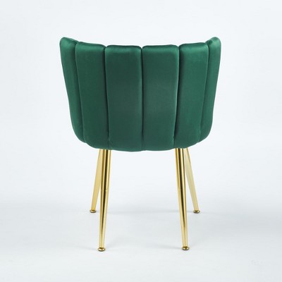 Rear-left angle view of green velvet dining chair with gold legs.