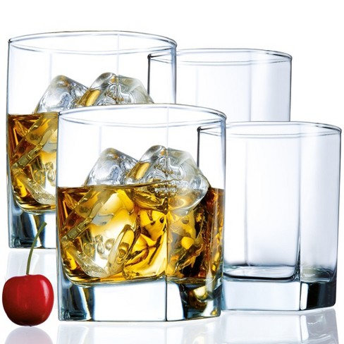 Crystal whiskey glass with ice cubes on a wooden table. Stock