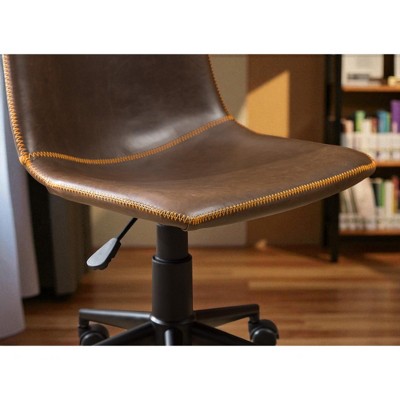 Close-up of brown leather chair seat edge and stitching