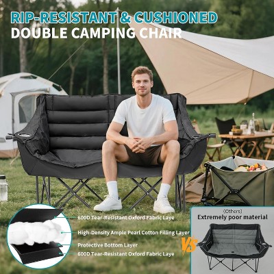 Man sitting on the double camping chair at a campsite with camping gear