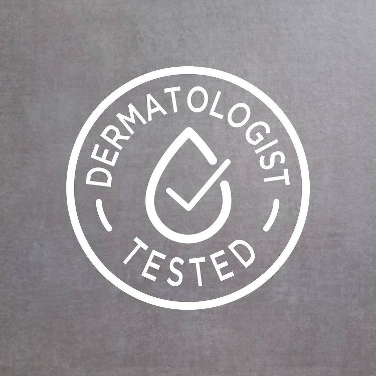 A circular logo with the text "DERMATOLOGIST TESTED" surrounding a droplet and checkmark symbol on a gray background.