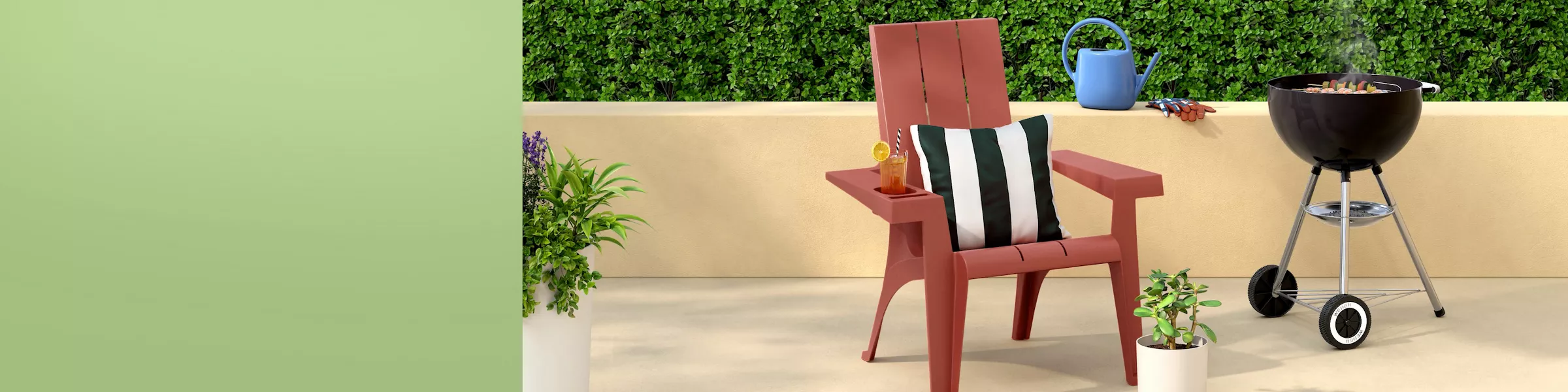 Sunny patio with red Adirondack chair, striped pillow, lemonade, charcoal kettle grill cooking skewers, watering can, and potted plants against green hedge and sky.