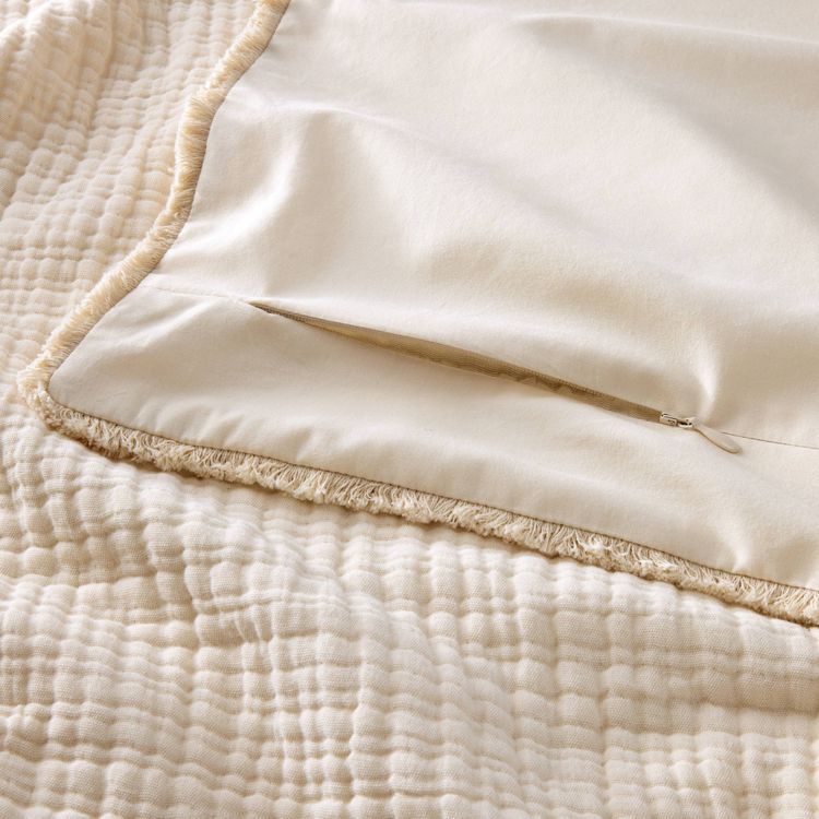 Textured chambray comforter in natural color with a visible zipper closure, showing a soft, quilted pattern.