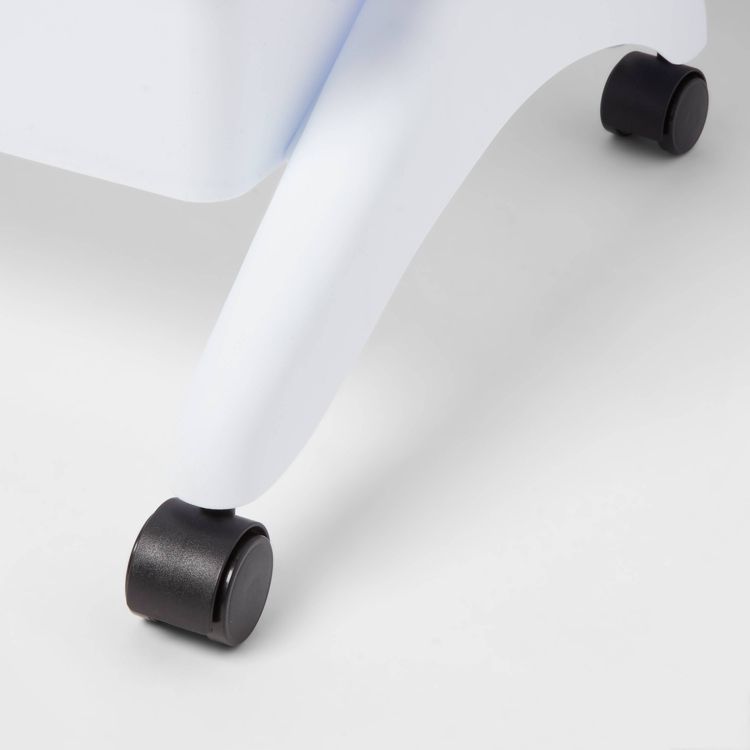 White utility cart with a close-up of a black wheel on a smooth surface.