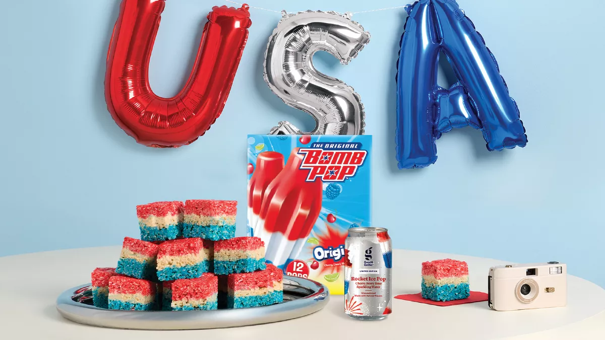 USA balloon in red, silver and blue. Over a table with red, white and blue rice treats. Along with bomb pops popsicles and a rocket pop good & gather flavored water.