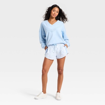 Light blue colored sweatshirt with a V-neck and lace detailing on the front.