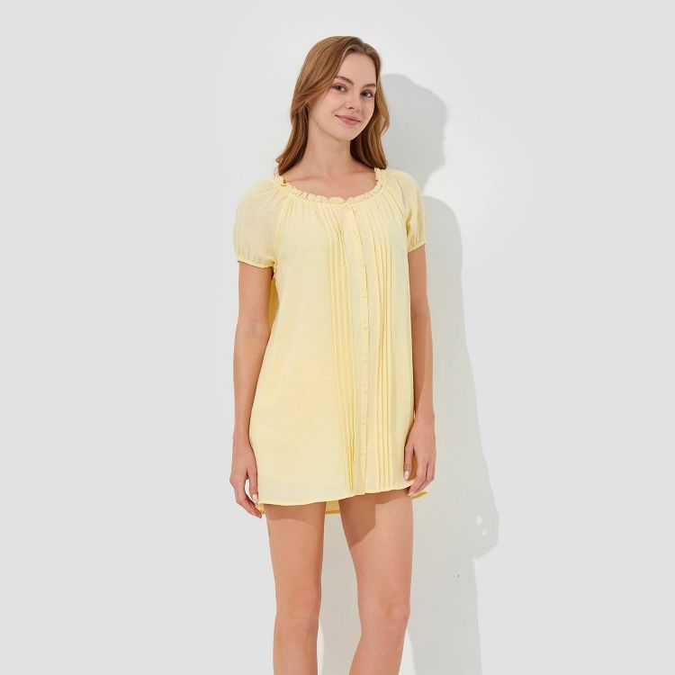 A light yellow colored short dress with a round neckline and button-down front.