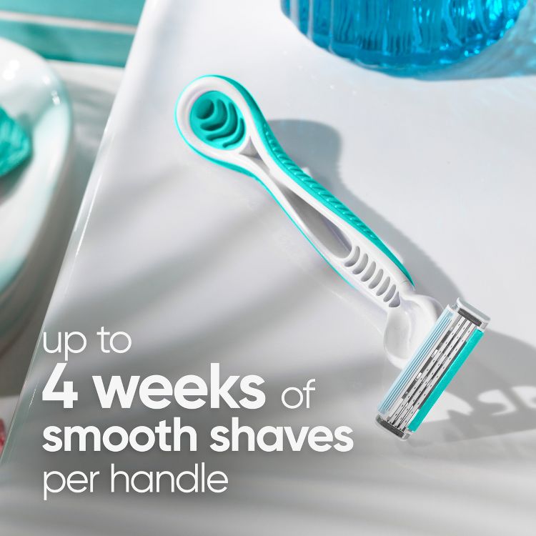 White and teal colored disposable razor with a three-blade cartridge and textured handle, with text on the image reading "up to 4 weeks of smooth shaves per handle".