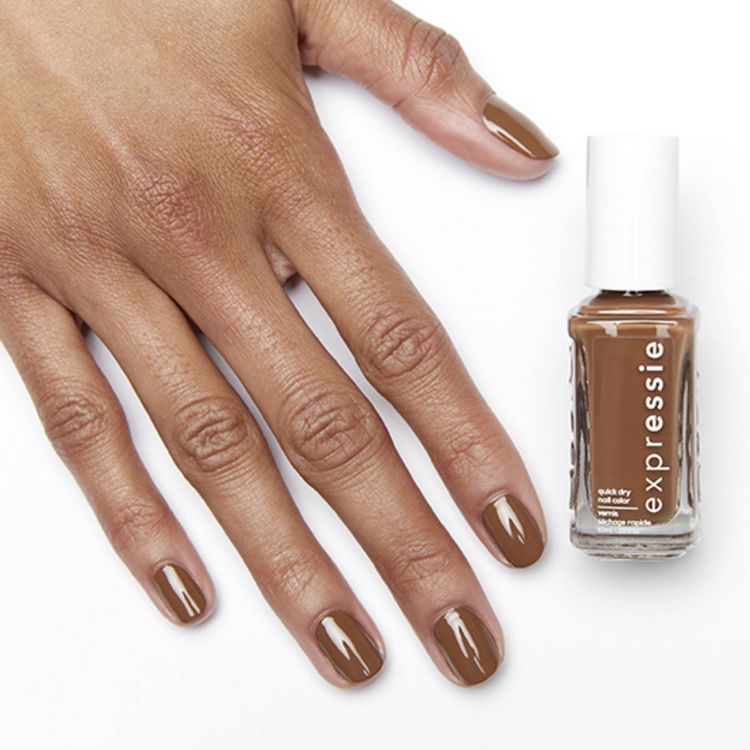 A hand with nails painted in brown colored nail polish next to a bottle labeled "expressie" containing the same shade.