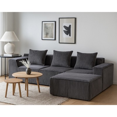 Gray corduroy modular sofa in living room setup with tables