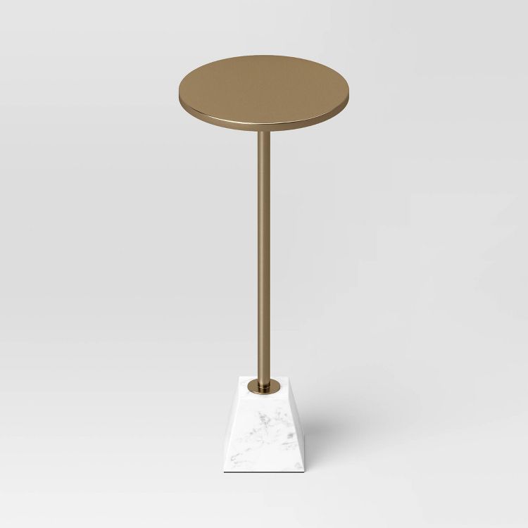 A round, brown colored end table with a slender stand and a white marble-like square base.