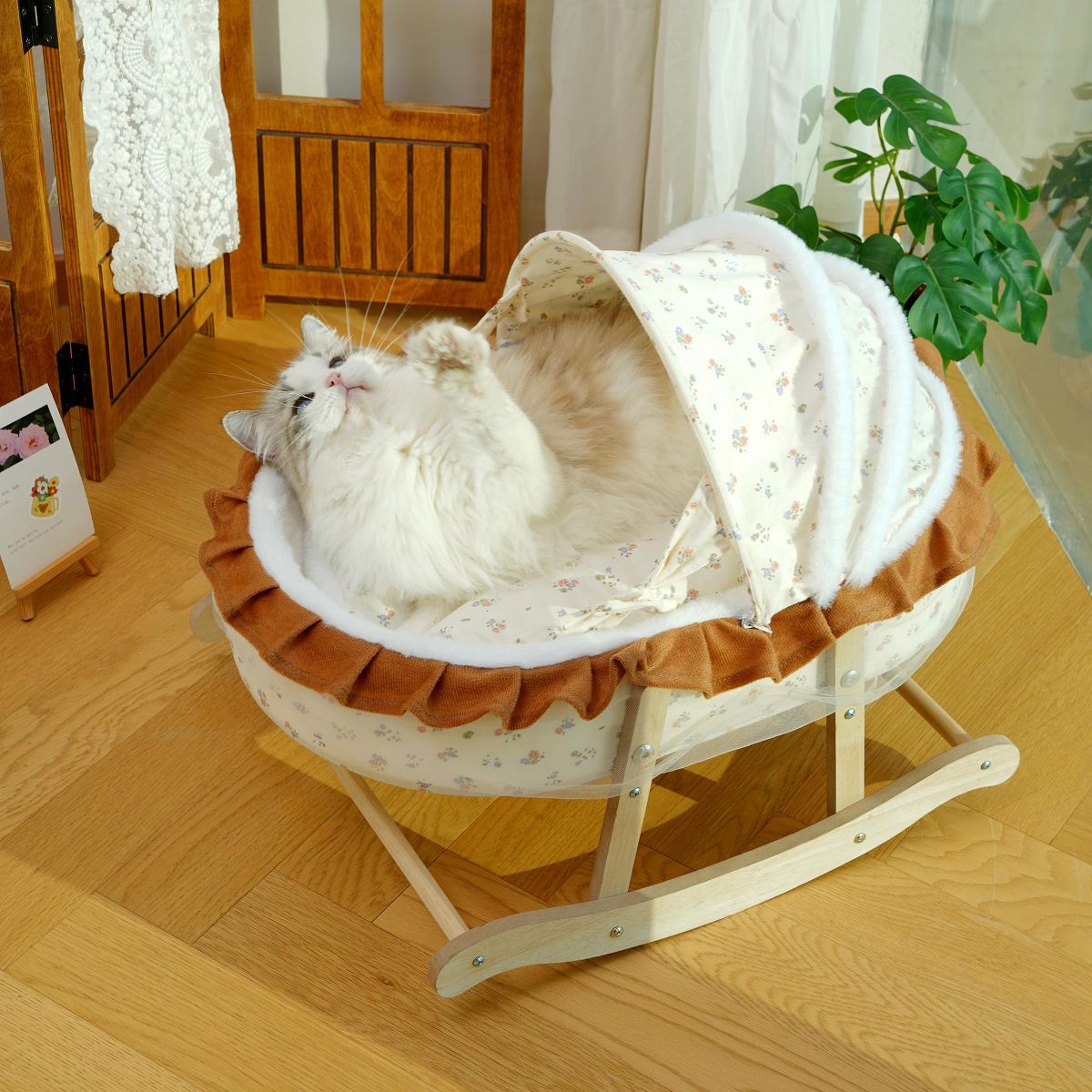Fluffy cat in a floral French-style rocking cat bed