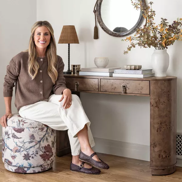 Shea McGee sitting on swivel ottoman in entry