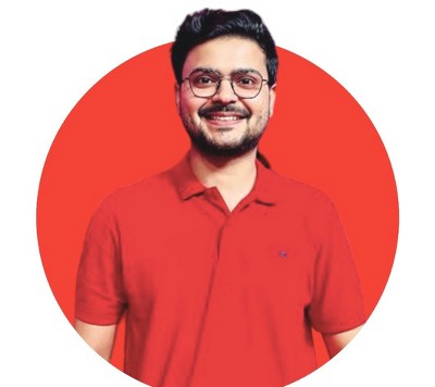 Lead data scientist Utsav Mishra, with medium skin tone and glasses, with a smile, a red polo shirt, and a trim beard, set against a red circular background.