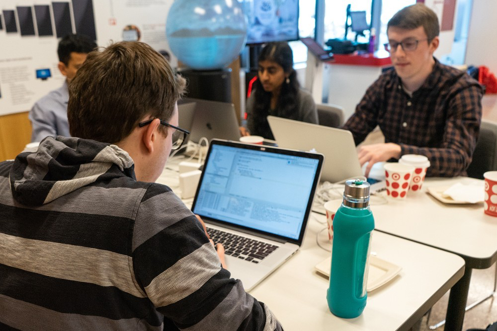image of four Target engineers seated at a table working on their four individual laptops 